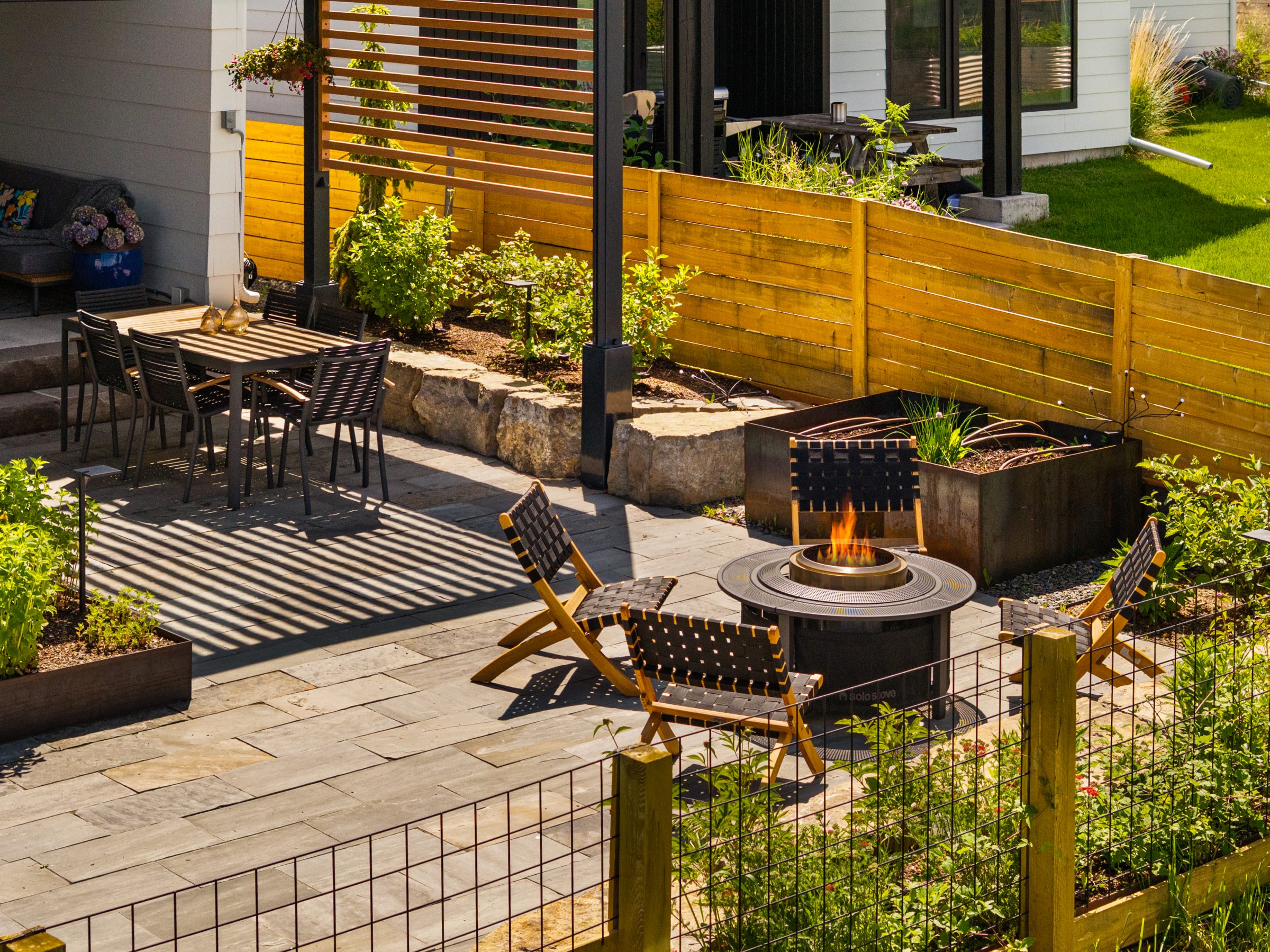Modern backyard patio with fire pit and dining set