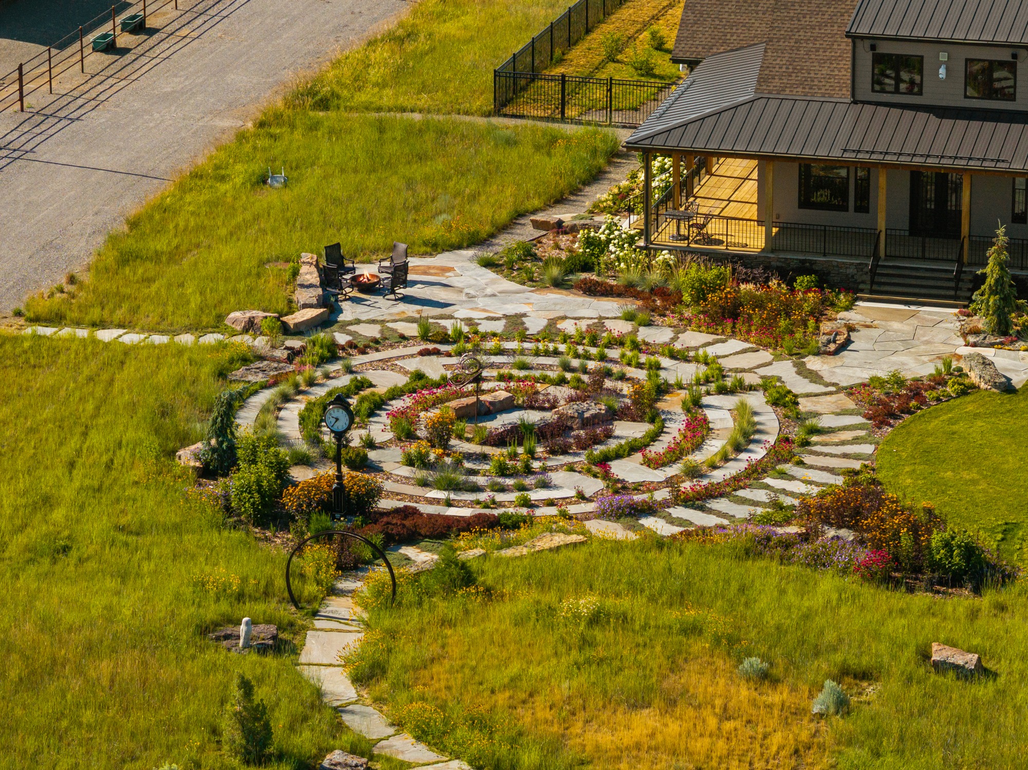 Landscaped backyard with stone labyrinth and patio seating