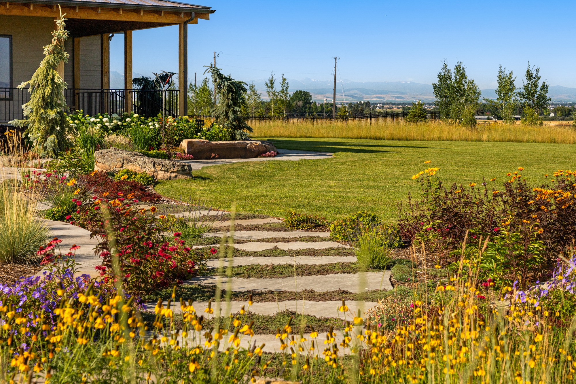 Landscaped backyard garden with stone path and mountains