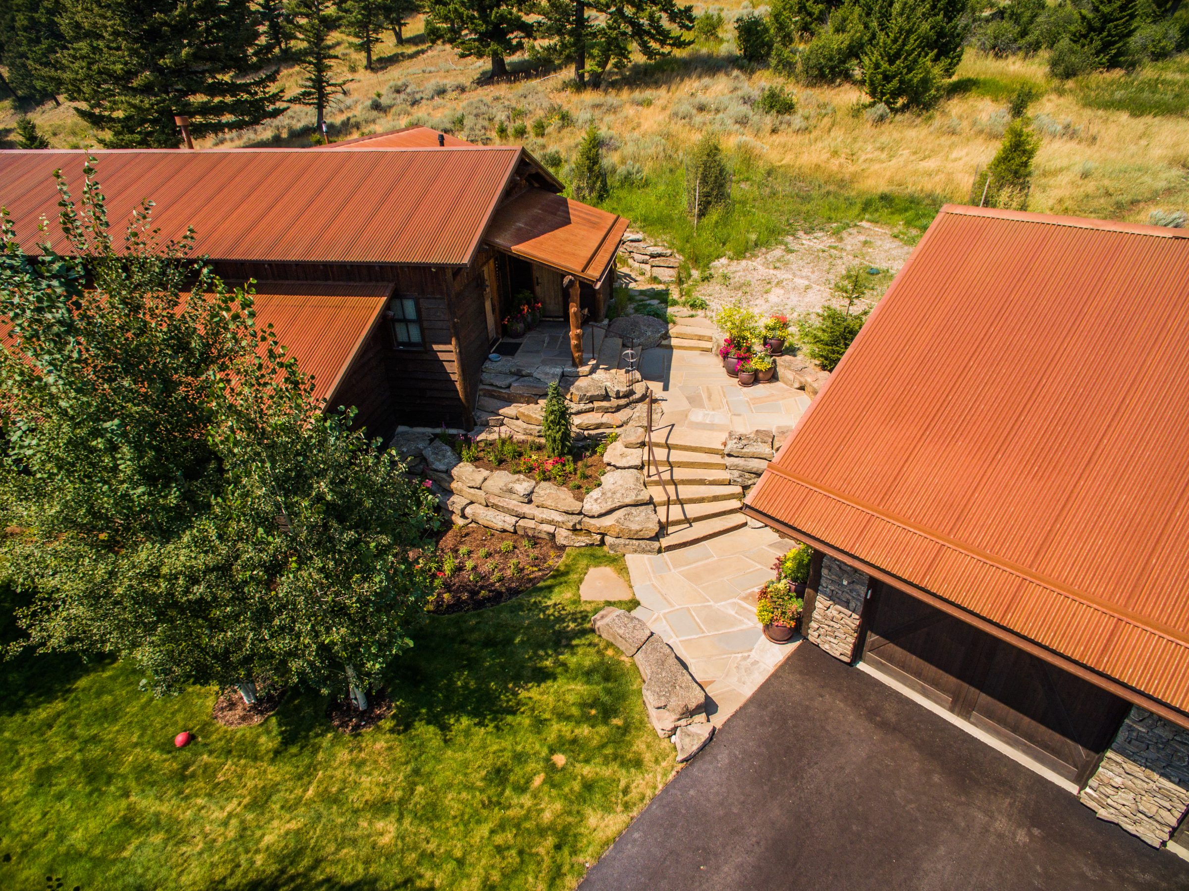 Aerial view of rustic home with stone patio