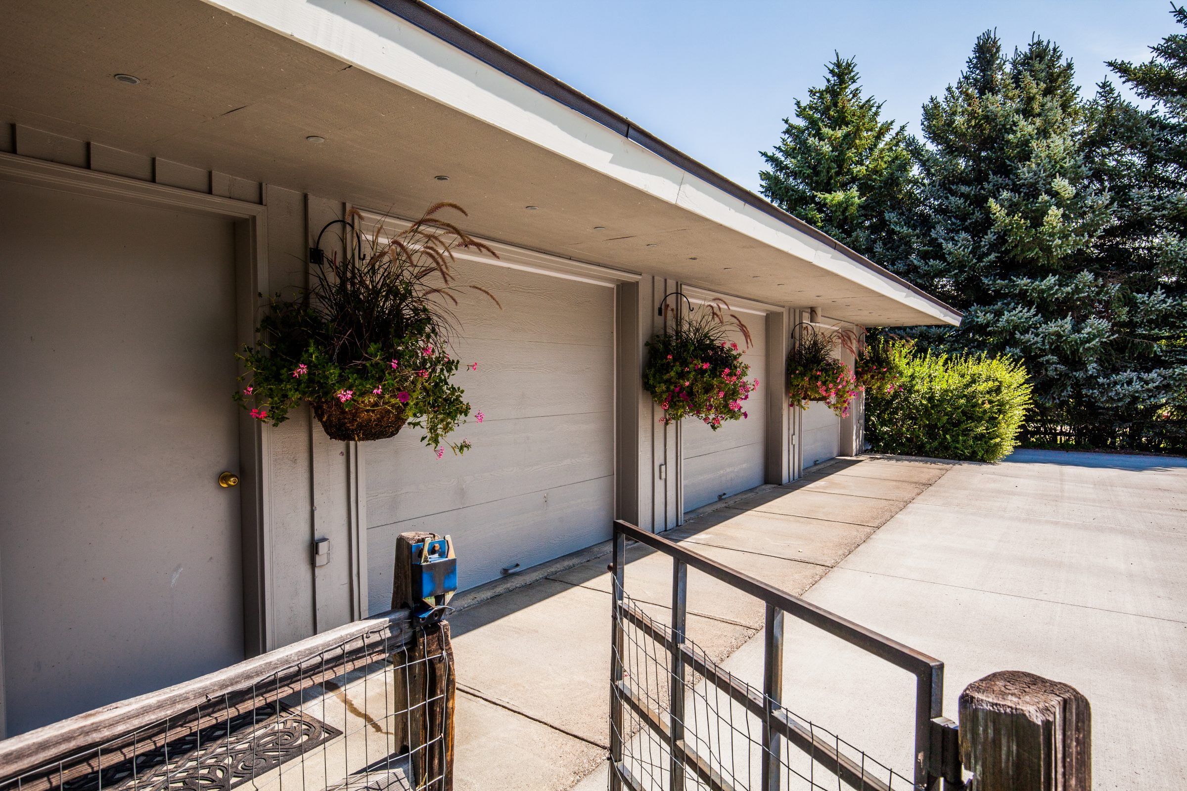 Residential garage with hanging flower baskets and driveway