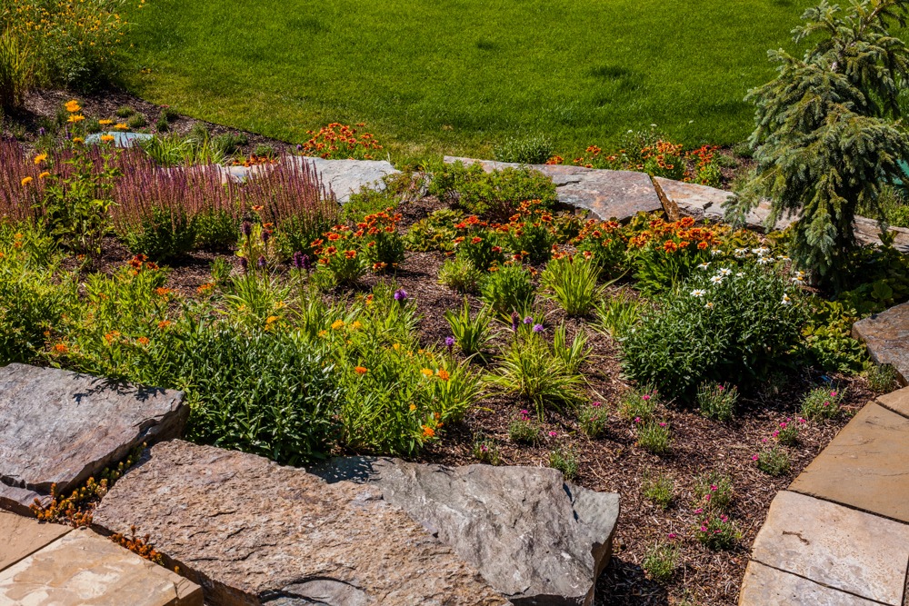 Colorful landscaped garden with stone border and flowers