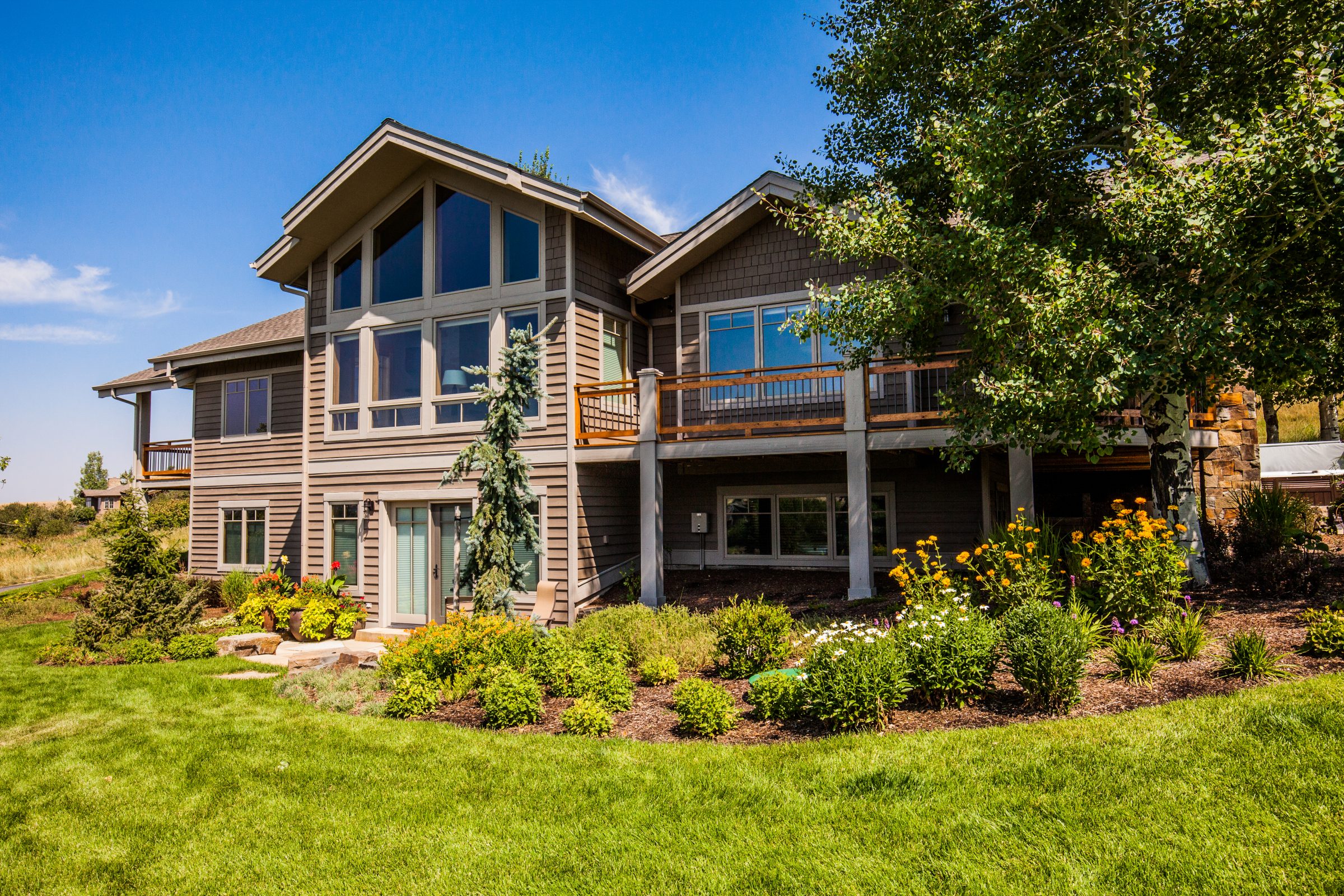 Modern two-story house with landscaped yard and deck