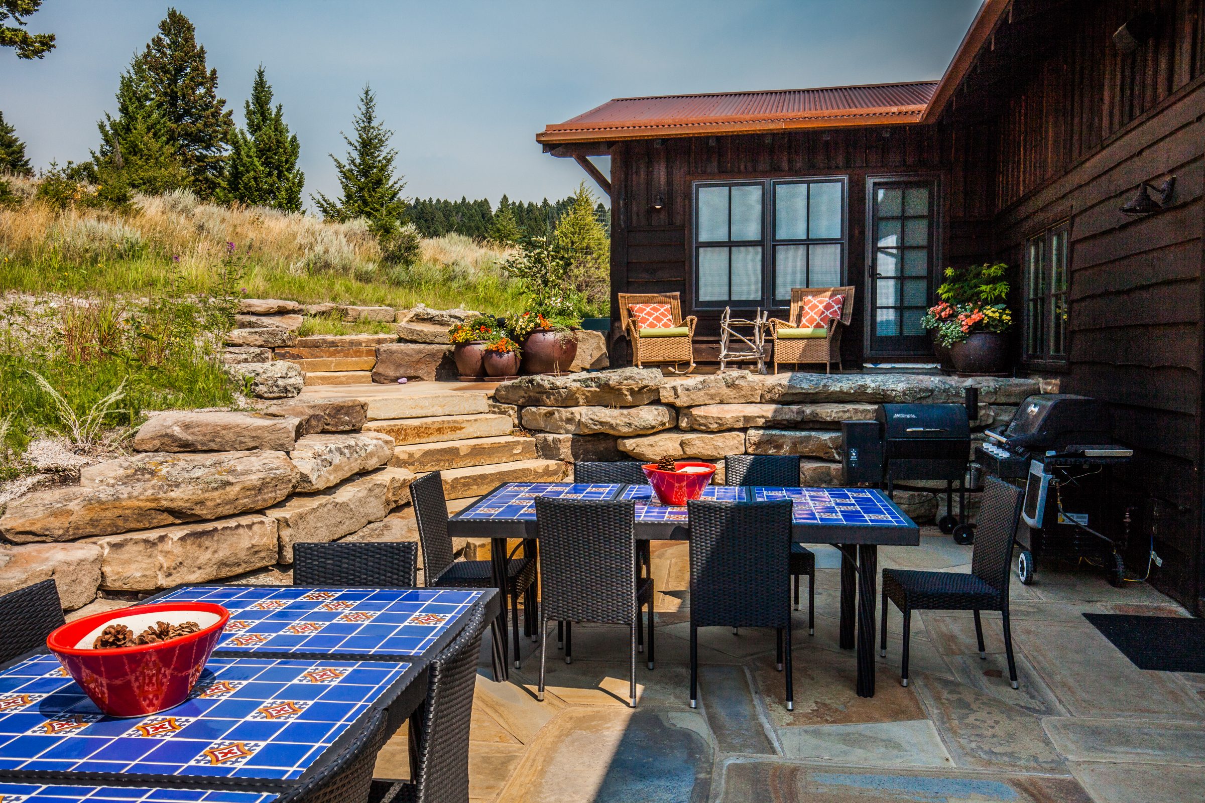 Rustic cabin patio with stone steps and tables