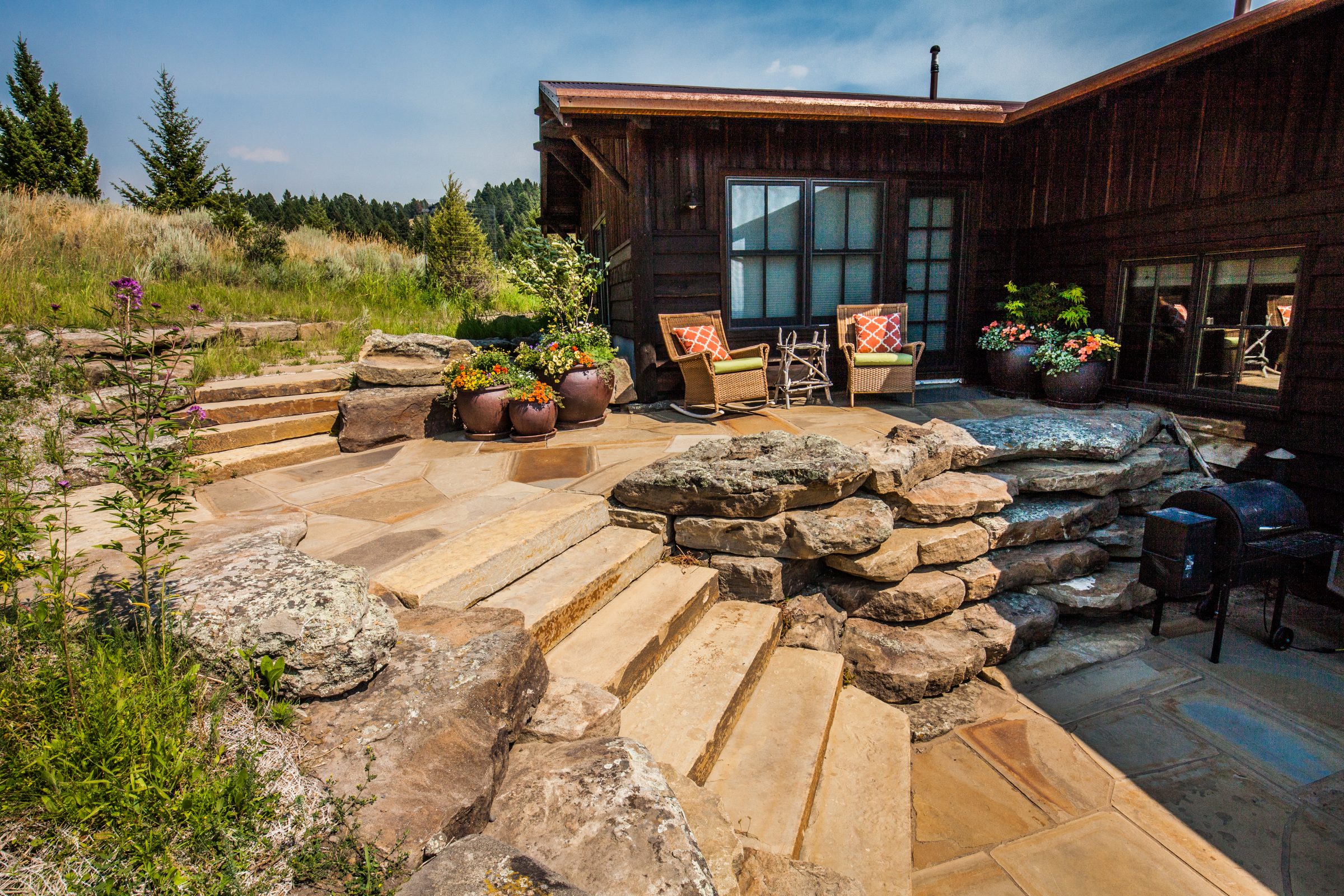 Rustic wooden home with stone patio and steps