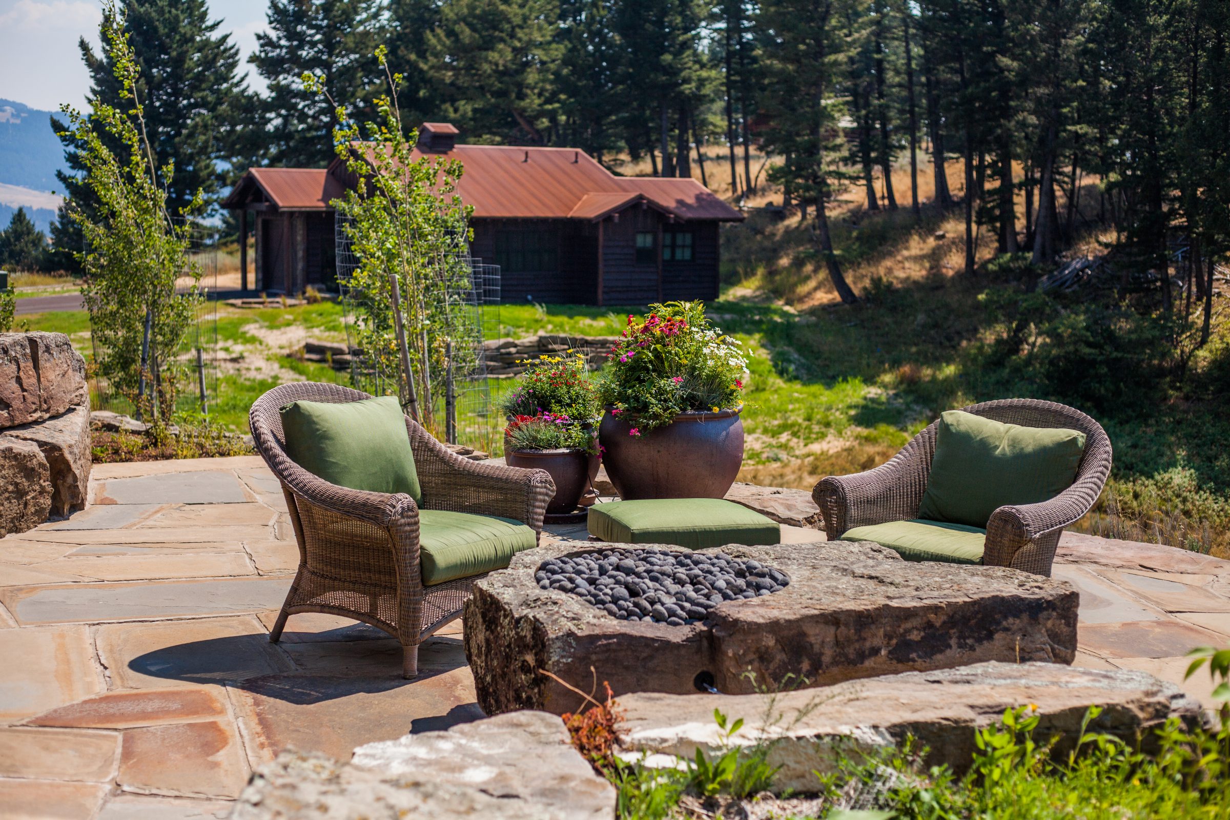 Stone patio with chairs and cabin view