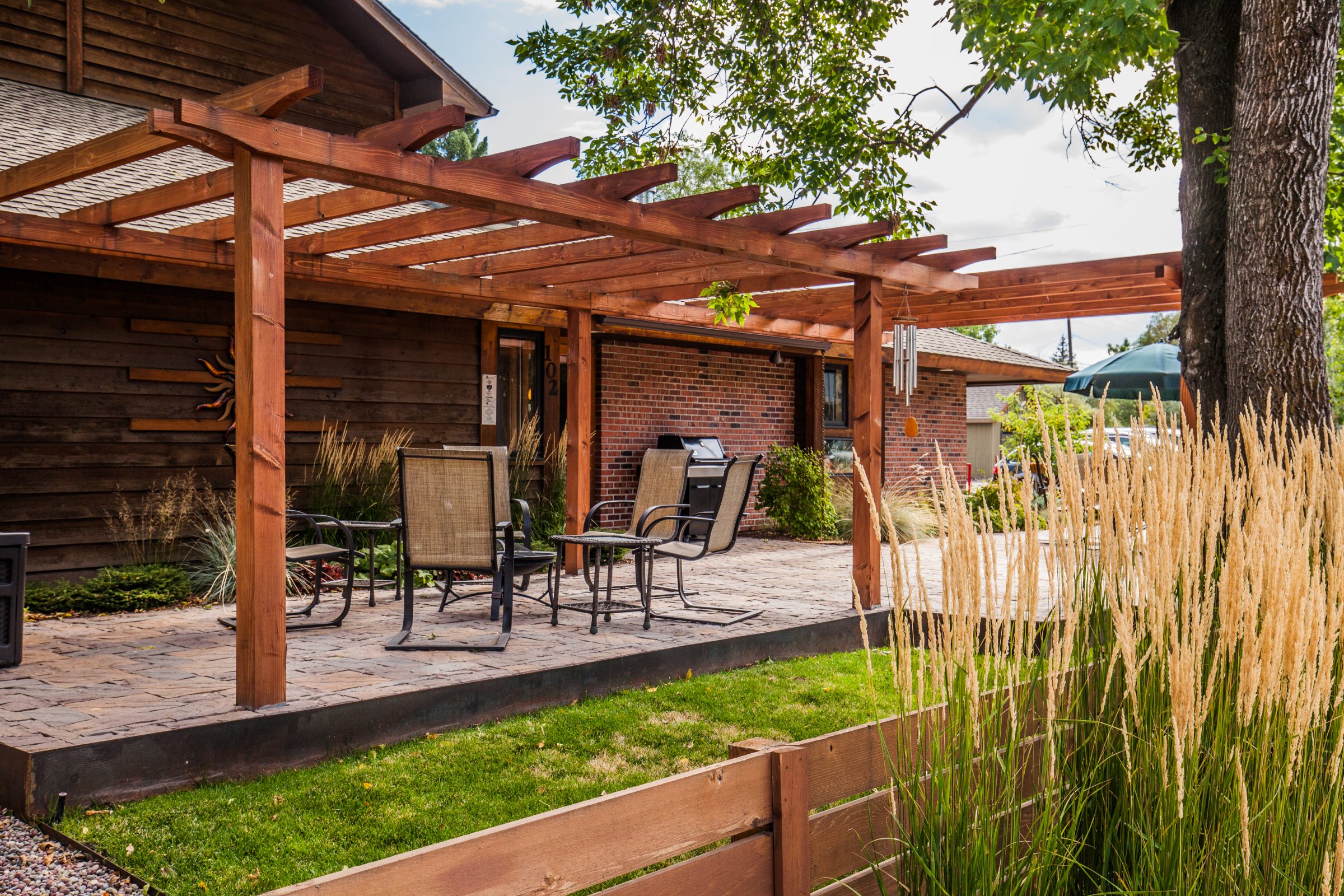 Backyard patio with wooden pergola and seating area