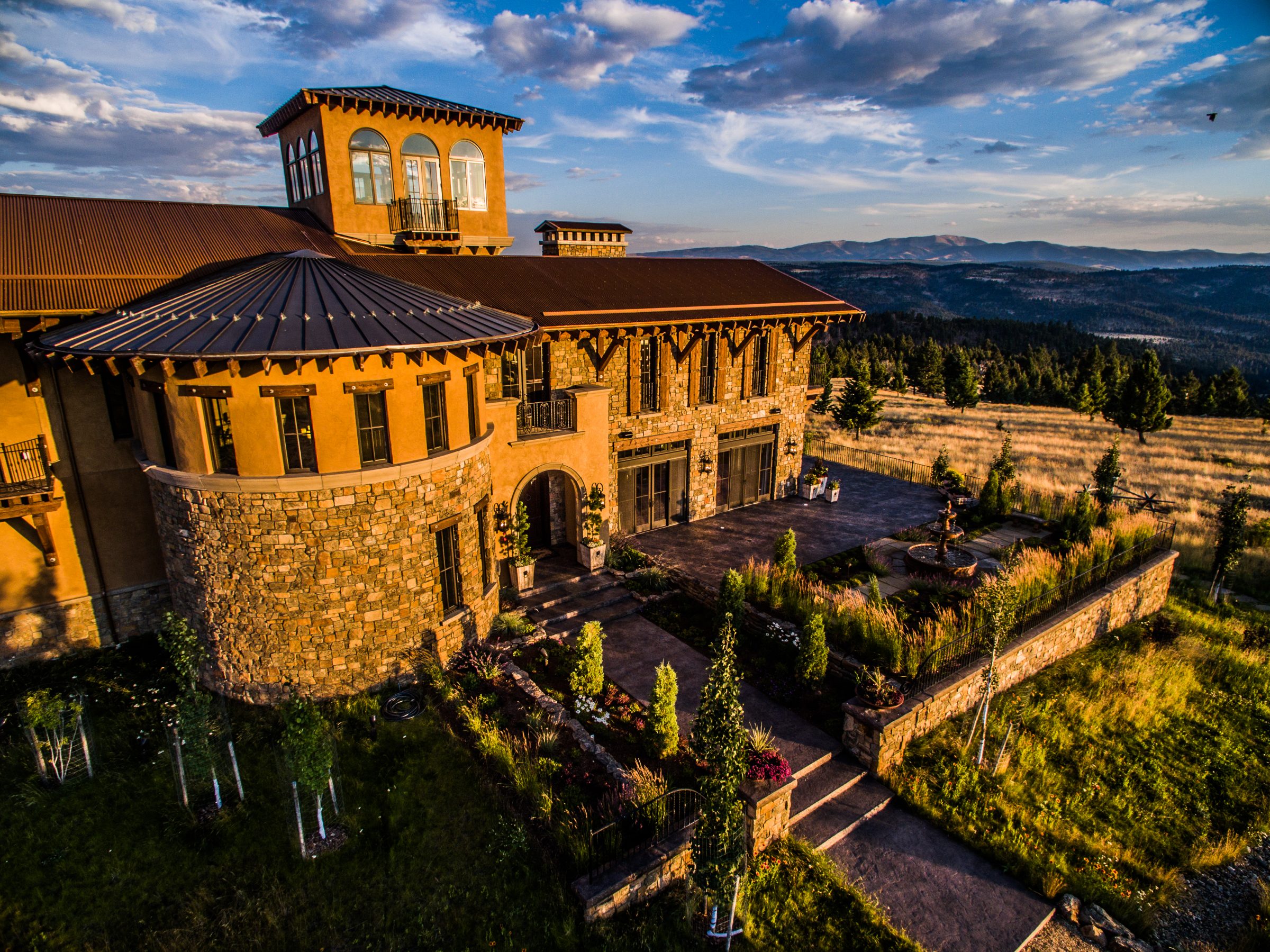 Luxury hillside stone home at sunset