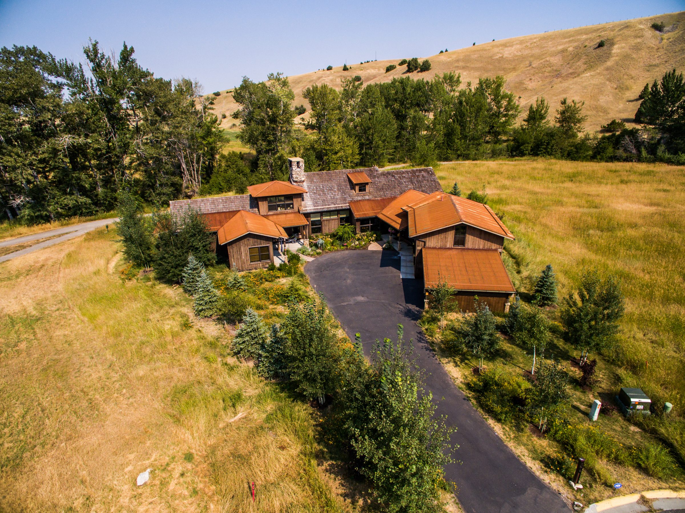 Aerial view of rustic home in grassy hills