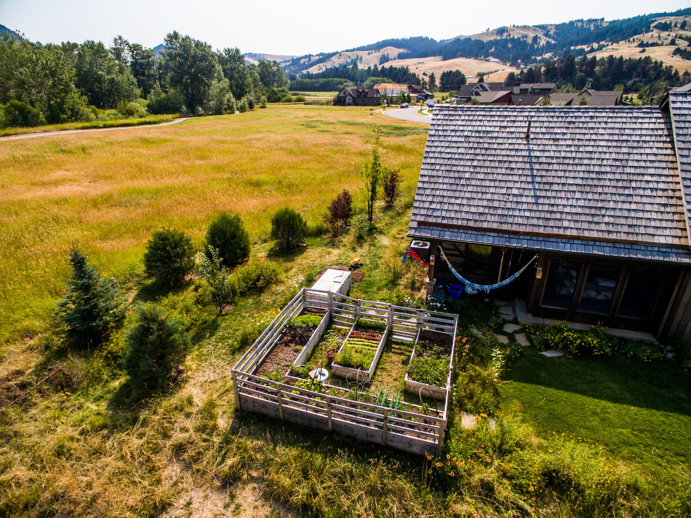 Rural home with garden beds and hills