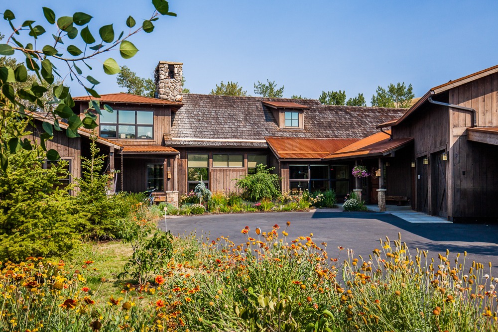 Rustic wooden home with landscaped garden and driveway