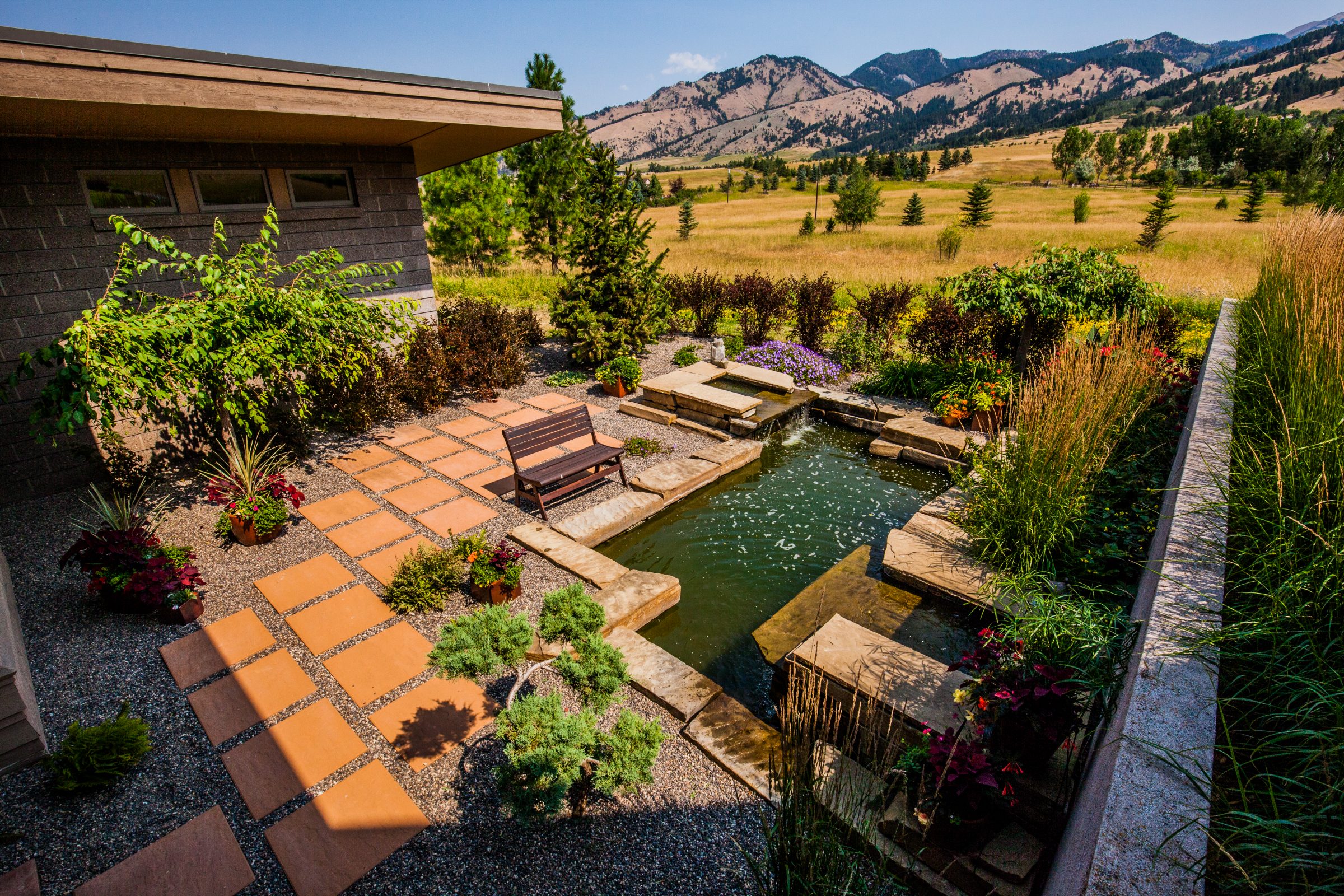 Landscaped backyard with pond and mountain view