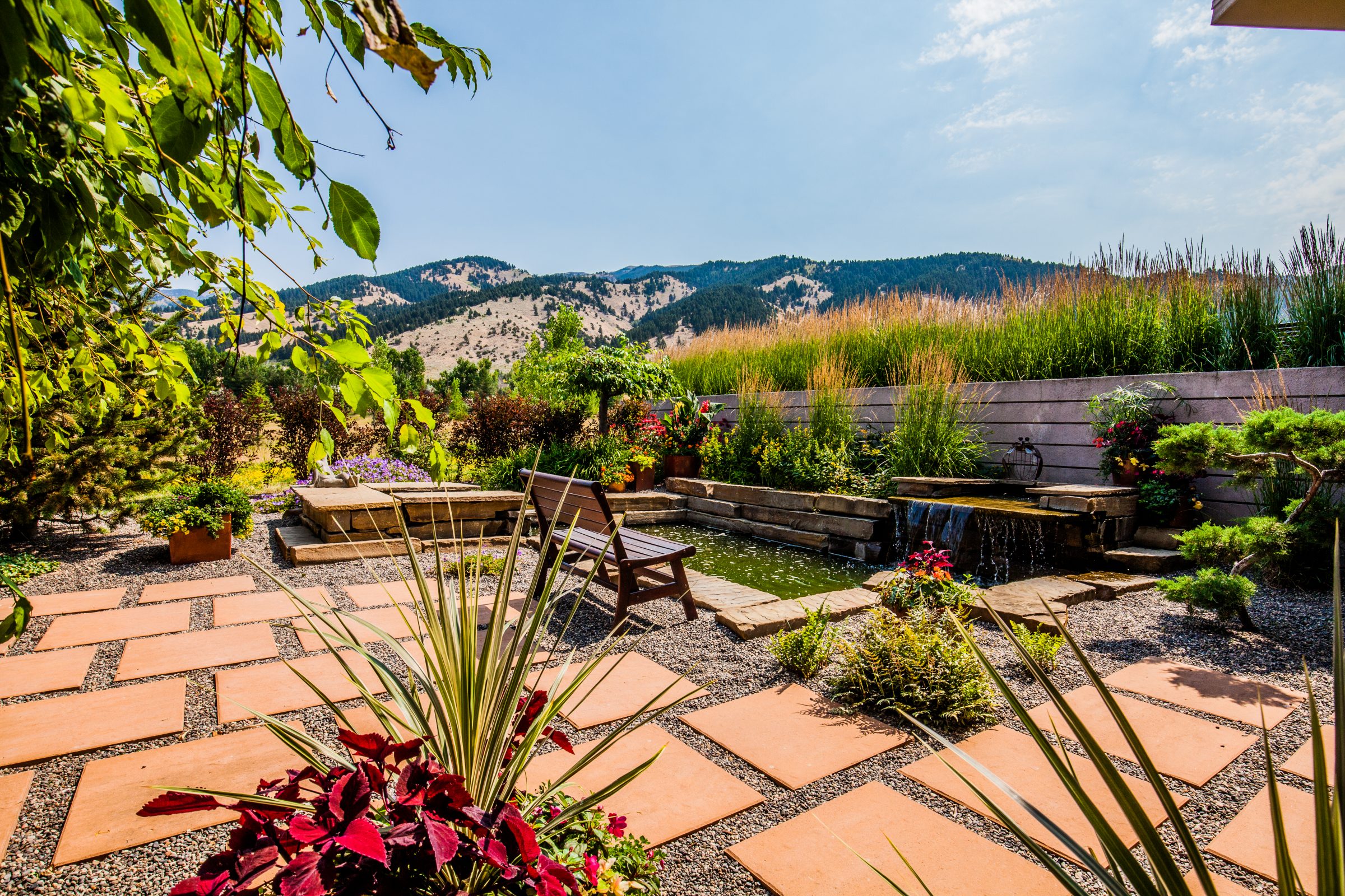 Landscaped backyard patio with pond and mountain view