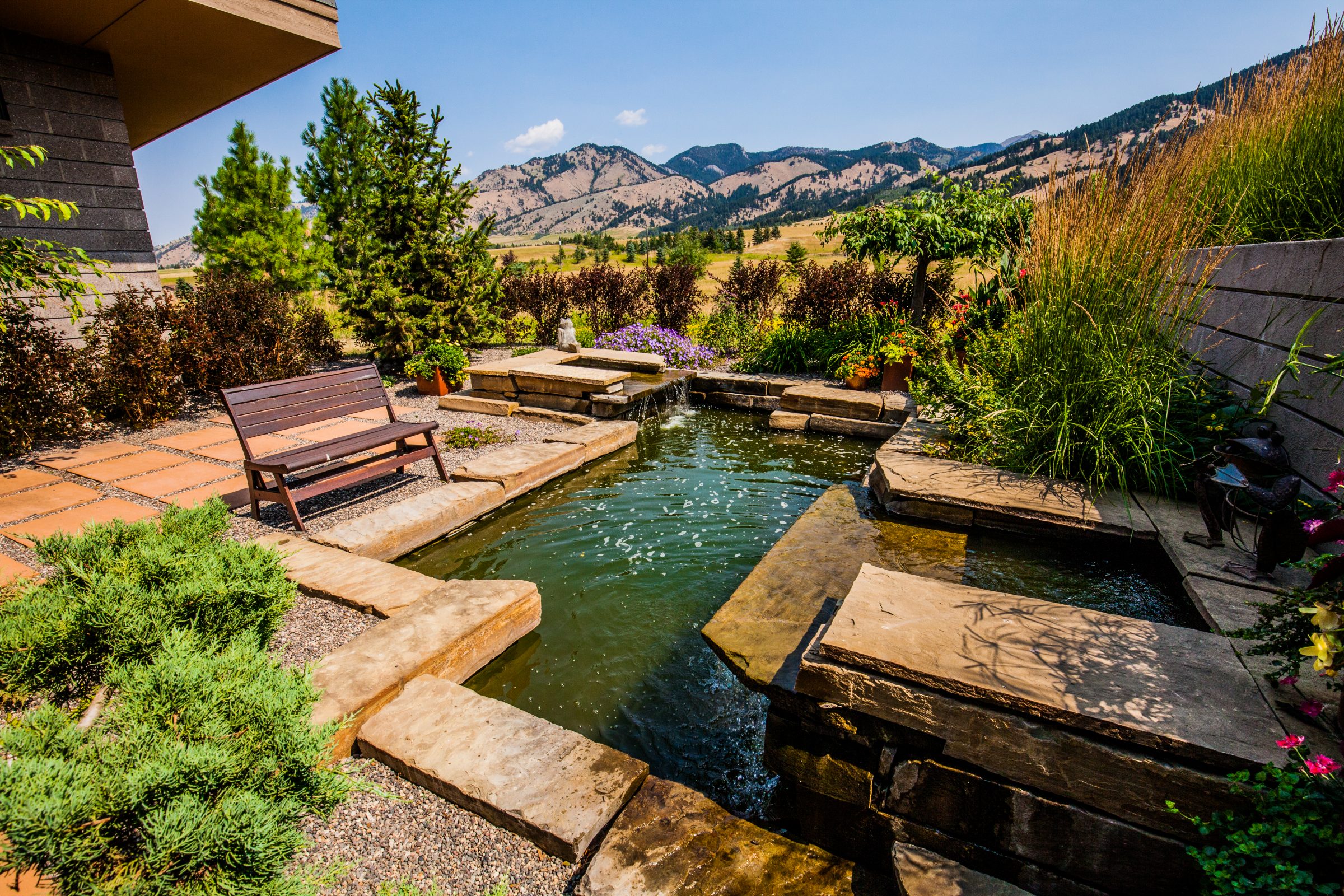 Landscaped backyard pond with mountain view