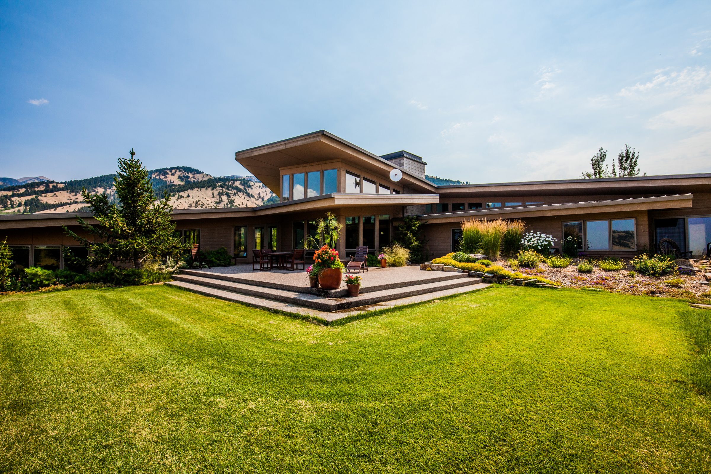 Modern hillside home with patio and lawn