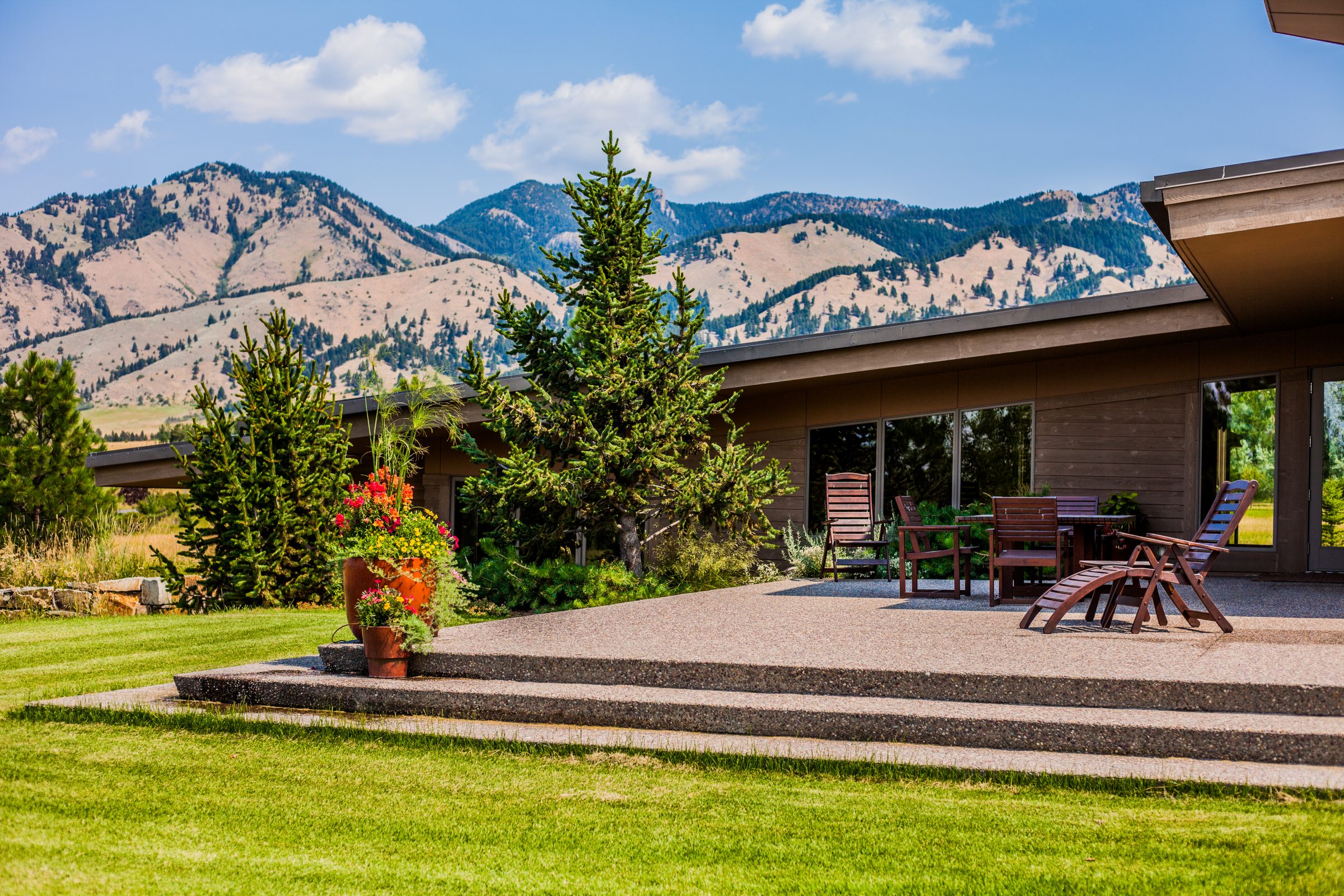 Modern patio with mountain view and wooden furniture