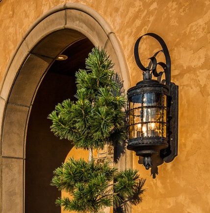 Elegant stone home entrance with potted topiary trees