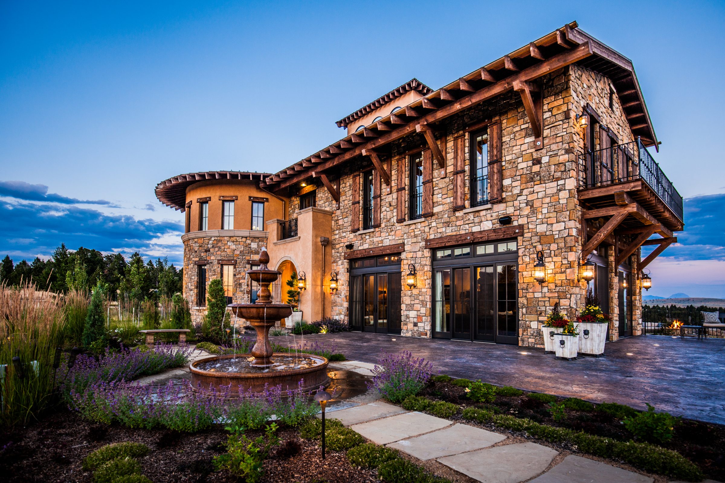 Luxury stone home with fountain at dusk