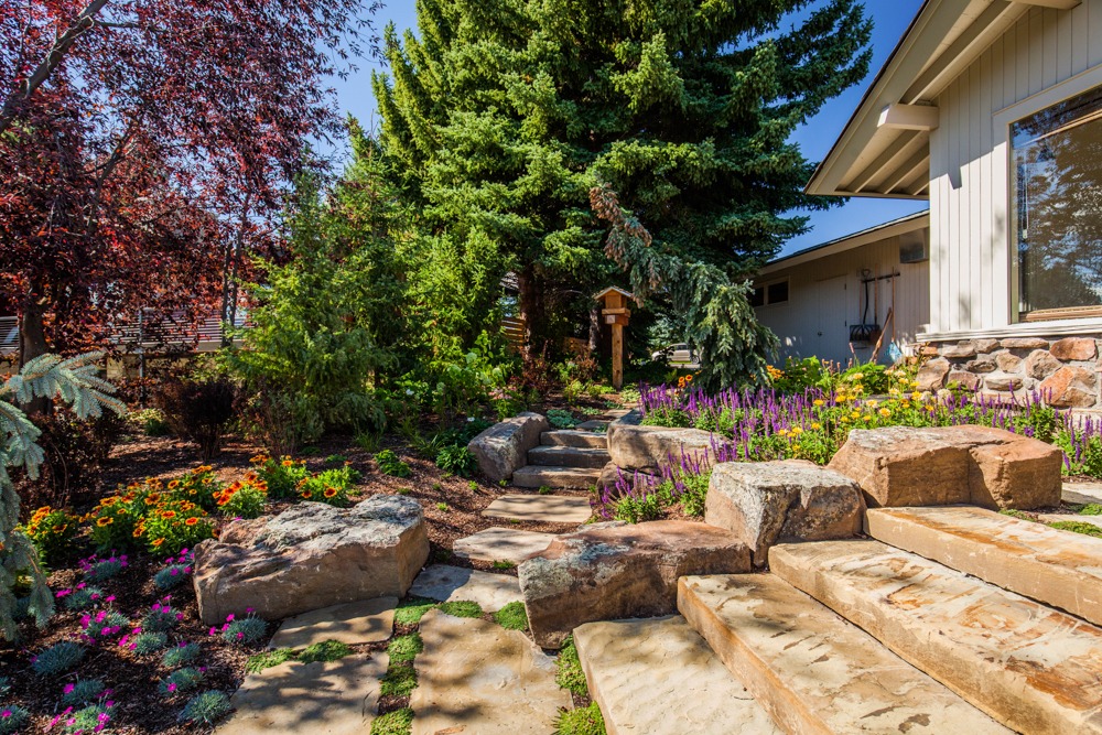 Landscaped backyard with stone steps and flowers