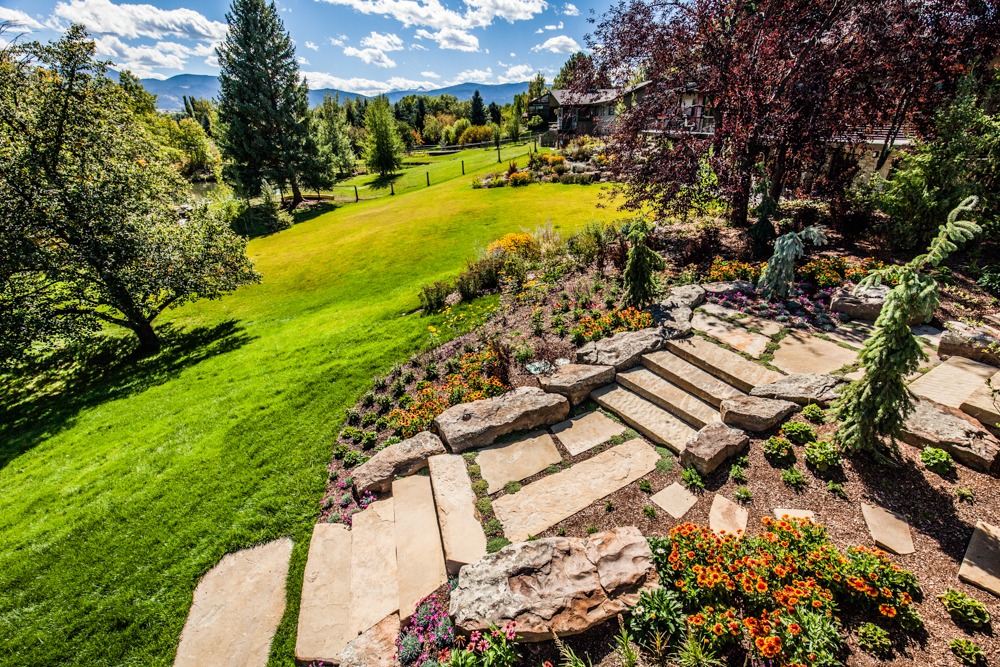 Landscaped backyard with stone steps and mountain view