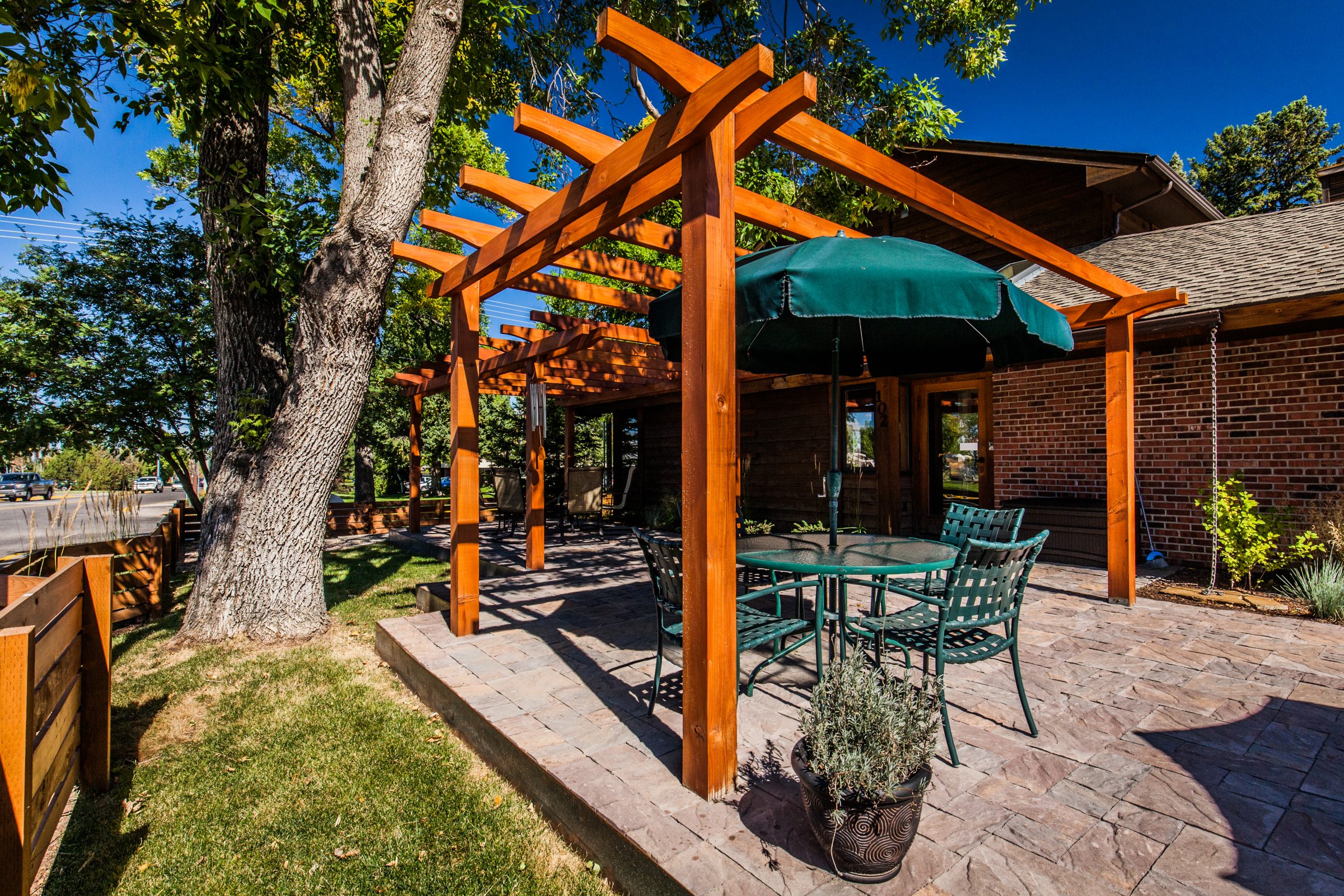 Wooden pergola over backyard patio with table