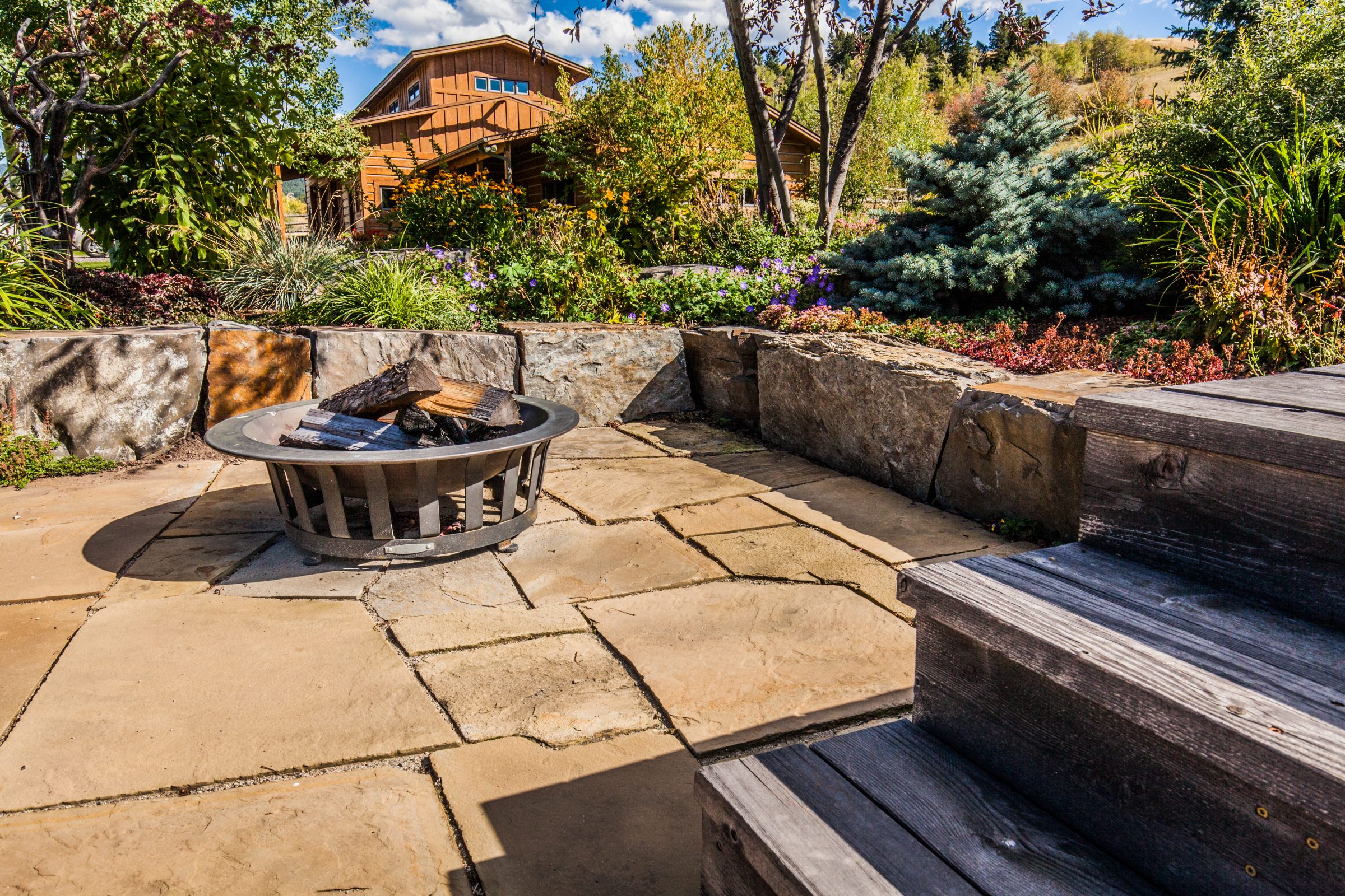 Landscaped backyard patio with fire pit and seating