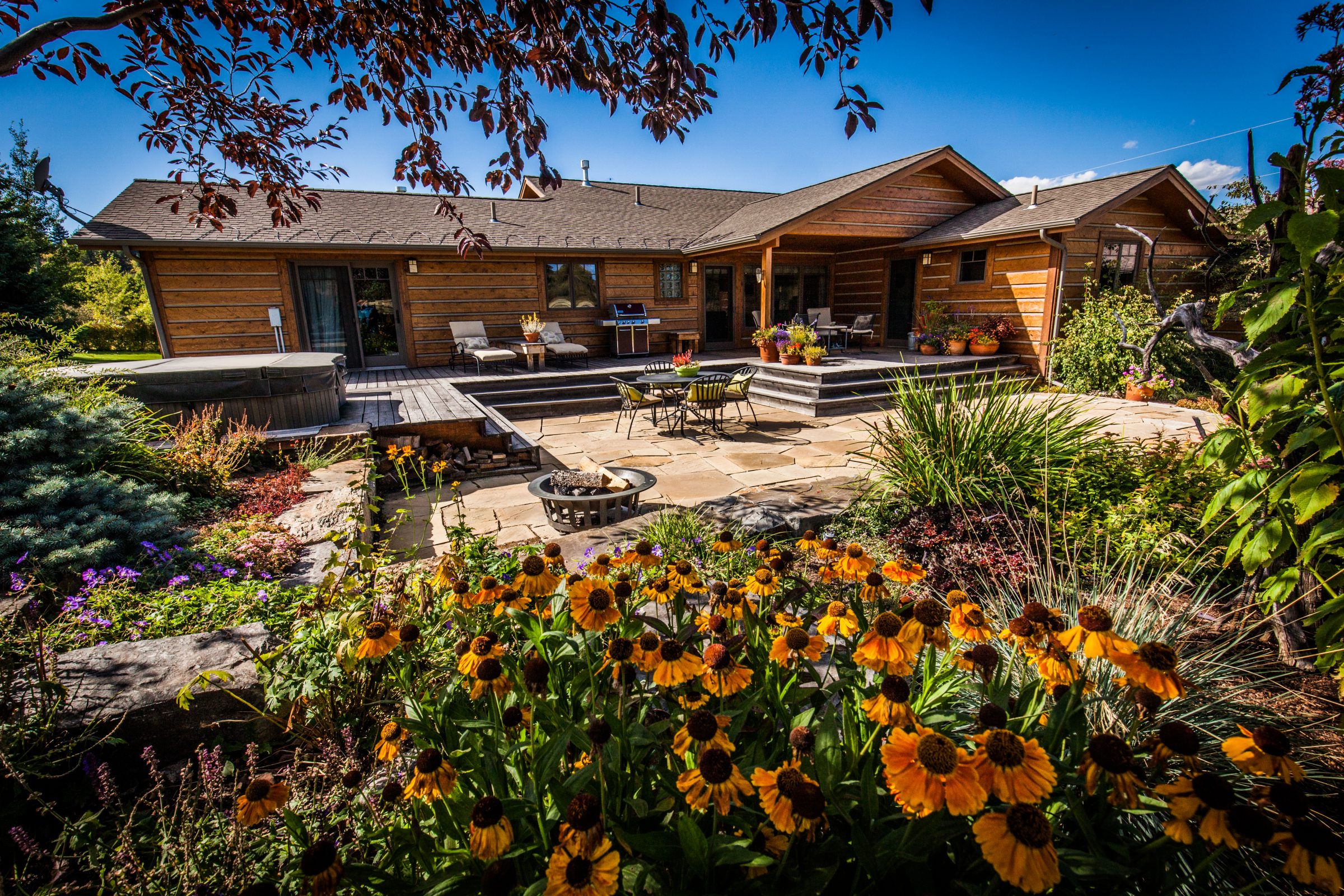 Wooden home with landscaped patio and garden