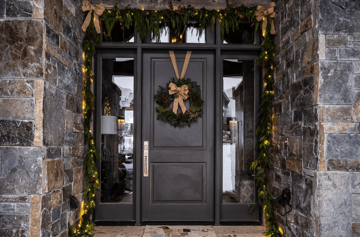 Front door with Christmas wreath and garland lights